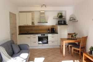 a kitchen with a couch and a table in a room at Ferienwohnung Am Waldrand in Saxler