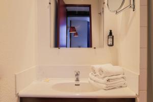 a bathroom with a sink and a mirror and towels at Hôtel Les Trois Luppars in Arras +40 photos