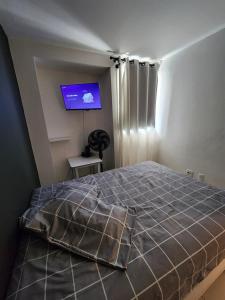 a bedroom with a bed and a flat screen tv at 4º Città Residence - Piscina e academia in Brasília +13 photos
