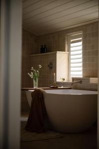 a bathroom with a tub and a vase of flowers at Lawsons Estate on Macquarie Farm in Brewongle +59 photos