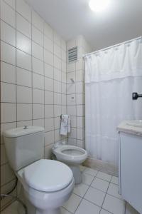 Un baño blanco con inodoro y ducha. en Punta! Bem localizado e completo!, en Punta del Este