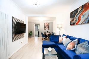 a living room with a blue couch and a table at 2BR Near Tottenham Stadium - WiFi - Free Parking in Ponders End