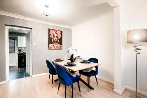 a dining room with a table and blue chairs at 2BR Near Tottenham Stadium - WiFi - Free Parking in Ponders End +32 photos
