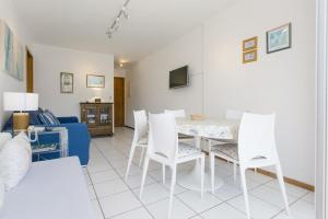sala de estar con mesa blanca y sillas blancas en Punta! Bem localizado e completo!, en Punta del Este