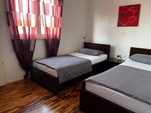 ein Schlafzimmer mit zwei Betten und einem Fenster mit roten Vorhängen in der Unterkunft Dija Riva 1 in Vabriga + 11 Fotos