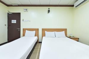 two beds in a room with a door at Hotel O Pendang Lake Formerly D Jiwa in Pendang