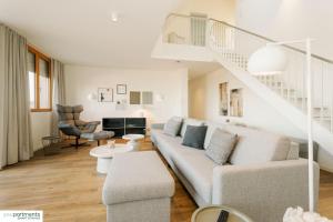 a living room with a couch and a staircase at 119 QM - Exklusiv auf 2 Etagen - Werse Loft by youpartments in Münster