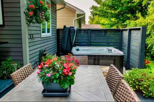 a patio with a table with flowers and a tub at The Studio Southampton in Southampton