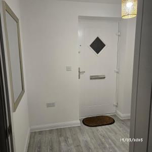 a hallway with a white wall and a door at Halton haven Three bed house sleeps 8 in Halton +12 photos