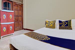 two twin beds in a room with a door at Hotel O Puri Kasih Guest House Syariah in Solo