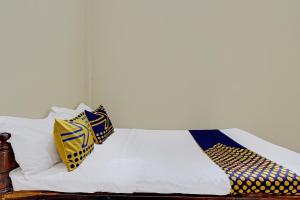 a bed with two pillows on top of it at Hotel O Puri Kasih Guest House Syariah in Solo
