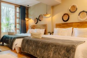 two beds in a hotel room with two beds at M de oro Apartamentos Muuk boutique POBLADO in Medellín
