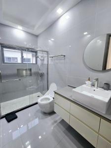 a white bathroom with a toilet and a sink at The Onyx Villa by MTJ Properties Ocho Rios in Laughlands +20 photos