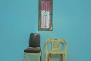 two chairs and a window on a blue wall at Hotel O Azeela Kost Syariah in Banjarmasin +19 photos