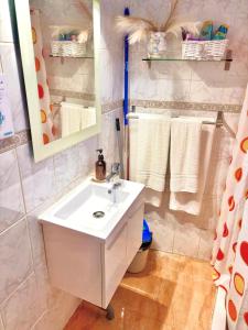 a bathroom with a sink and a mirror and towels at Gloria Suites at Pension Candelaria in Valle Gran Rey