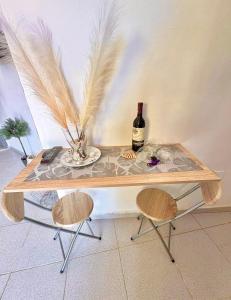 a table with a bottle of wine and two chairs at Gloria Suites at Pension Candelaria in Valle Gran Rey +12 photos
