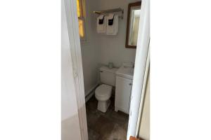 a bathroom with a toilet and a mirror at Love Hotels Timberline By OYO Lake Superior in Ironwood