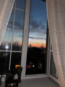an open window with a view of a sunset at ELAY Apartments in Baku