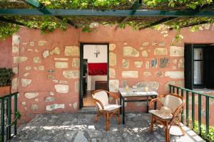 a patio with two chairs and a table on a balcony at Rigas traditional hospitality in Embrósneros