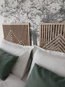 two wooden chairs with pillows in front of a wall at Gîte Héloïse in Le Pallet