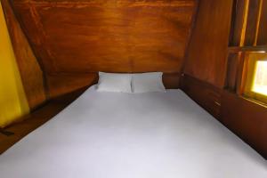 a bed in a small room with a window at Hotel O Awenk Homestay Near SD Gunung Wakul in Labuan Lombok