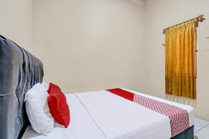 a bedroom with a bed with a red and white blanket at OYO 92459 Cahyo Kost 2 in Semarang