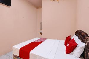 a bedroom with a bed with red and white at OYO 92459 Cahyo Kost 2 in Semarang +18 photos