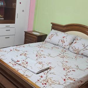 a bedroom with a bed with red flowers on it at Villa Topuzi Second Floor in Pogradec
