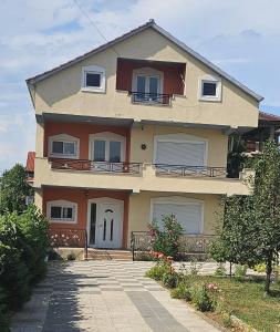 a large house with a driveway in front of it at Villa Topuzi Second Floor in Pogradec