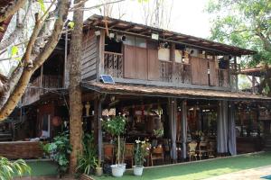 ein Gebäude mit einem Balkon sowie Tischen und Stühlen in der Unterkunft Capital O 75421 Baan Singkham Boutique Resort in Chiang Mai