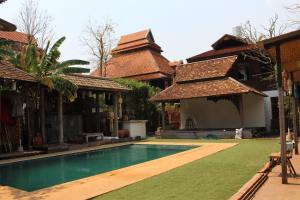 ein Haus mit einem Swimmingpool im Hof in der Unterkunft Capital O 75421 Baan Singkham Boutique Resort in Chiang Mai
