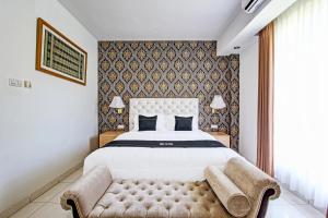 ein Schlafzimmer mit einem großen Bett und einer Couch in der Unterkunft Collection O Gunung Kidul Near Baron Beach Formerly Orchid Hotel in Duwet