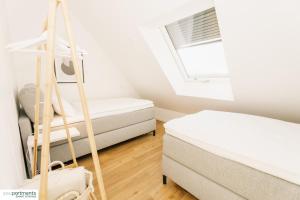 a bedroom with two beds and a window at 119 QM - Exklusiv auf 2 Etagen - Werse Loft by youpartments in Münster