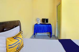 a room with a bed and a table with a blue table cloth at SPOT ON 92475 Rc Homestay Syariah in Banyuwangi