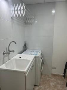 a white bathroom with a sink and a washing machine at Cómoda casa céntrica para 4 ó 5 personas in San Carlos de Bariloche +15 photos