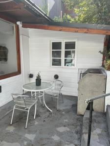 a patio with a table and chairs in front of a house at Cómoda casa céntrica para 4 ó 5 personas in San Carlos de Bariloche