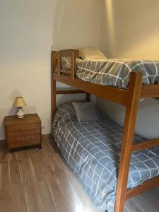 a bedroom with two bunk beds and a night stand at Cómoda casa céntrica para 4 ó 5 personas in San Carlos de Bariloche