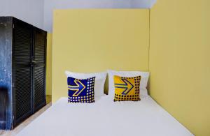 a bedroom with a bed with two pillows on it at SPOT ON 92480 Iwn Homestay Syariah in Banyuwangi