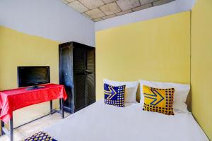 a bedroom with a bed with a television and a red table at SPOT ON 92480 Iwn Homestay Syariah in Banyuwangi