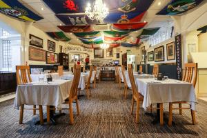 a restaurant with tables and chairs in a room at Lord Kitcheners Guest House in Lowestoft
