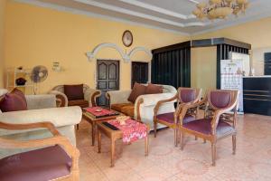 a living room with furniture and a clock on the wall at OYO 92497 Penginapan Pasir Indah SyariahNearMonument Park City Sand Pengaraian in Pasirpengarayan +22 photos