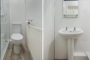 a white bathroom with a toilet and a sink at Lord Kitcheners Guest House in Lowestoft