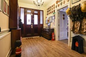 a room with a hallway with a door and a fire extinguisher at Lord Kitcheners Guest House in Lowestoft