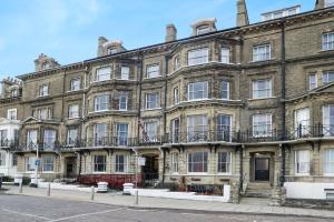a large brick building on the corner of a street at Lord Kitcheners Guest House in Lowestoft