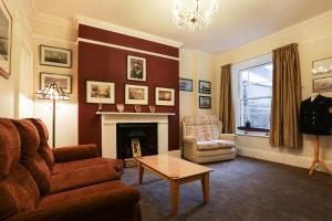 a living room with a couch and a fireplace at Lord Kitcheners Guest House in Lowestoft