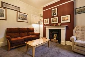 a living room with a couch and a fireplace at Lord Kitcheners Guest House in Lowestoft