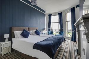 a bedroom with a large bed with blue walls at Lord Kitcheners Guest House in Lowestoft
