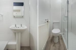 a white bathroom with a sink and a toilet at Lord Kitcheners Guest House in Lowestoft
