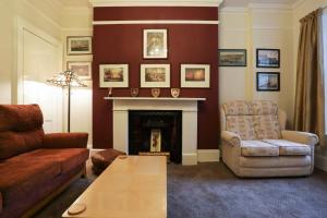 a living room with a couch and a fireplace at Lord Kitcheners Guest House in Lowestoft