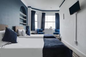 a hotel room with a large bed with blue pillows at Lord Kitcheners Guest House in Lowestoft